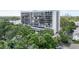 Multi-story condo building with balconies surrounded by lush greenery and ample parking at 3211 W Swann Ave # 605, Tampa, FL 33609