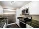 Bright kitchen featuring stainless steel appliances, custom cabinets, and attractive countertops at 3211 W Swann Ave # 605, Tampa, FL 33609