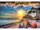 Inviting beach setting with Adirondack chairs, tiki umbrellas, and a cozy fire pit at sunset at 339 Club Manor Dr, Sun City Center, FL 33573