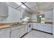 Clean white kitchen with laminate countertops, tile floors, and stainless sink at 339 Club Manor Dr, Sun City Center, FL 33573