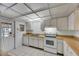 Clean kitchen with white appliances, light countertops and neutral tile flooring at 339 Club Manor Dr, Sun City Center, FL 33573