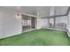 Enclosed lanai featuring sliding glass doors and green carpet, perfect for outdoor enjoyment at 339 Club Manor Dr, Sun City Center, FL 33573