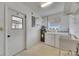 Bright laundry area features modern appliances and a practical utility sink, adjacent to a convenient exterior door at 339 Club Manor Dr, Sun City Center, FL 33573