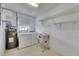 Functional laundry room with a washing machine, dryer, sink, and shelving for storage at 339 Club Manor Dr, Sun City Center, FL 33573