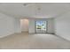 Large living area with neutral carpet, ceiling fan, and expansive street view window at 339 Club Manor Dr, Sun City Center, FL 33573