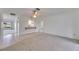 Bright living room with an open bar to the kitchen, neutral carpeting and access to hallway at 339 Club Manor Dr, Sun City Center, FL 33573
