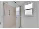 Enclosed shower with frosted sliding door and a window for natural light at 339 Club Manor Dr, Sun City Center, FL 33573