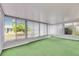 Bright sunroom featuring multiple windows for ample natural light, and unique green carpet at 339 Club Manor Dr, Sun City Center, FL 33573