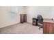 Bright bedroom featuring neutral walls, carpeted floor, desk, and decorative wood shelving at 33922 Jasper Stone Dr, Wesley Chapel, FL 33543