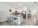 Open kitchen with island, white cabinets, stainless appliances, and tiled floors at 33922 Jasper Stone Dr, Wesley Chapel, FL 33543