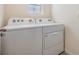 Clean laundry room with white washer and dryer units plus window at 33922 Jasper Stone Dr, Wesley Chapel, FL 33543