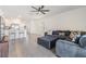 Open living room with large sectional sofa, ceiling fan, and views into the kitchen at 33922 Jasper Stone Dr, Wesley Chapel, FL 33543