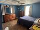 Stylish bedroom featuring rich blue walls, warm wood accents, and ample natural light at 34300 Countryside Dr, Wesley Chapel, FL 33543