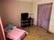 Bright bedroom showcasing pink accents, tile flooring, and a workstation at 34300 Countryside Dr, Wesley Chapel, FL 33543