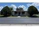 Charming home featuring a covered front porch, complemented by lush landscaping and mature trees at 34300 Countryside Dr, Wesley Chapel, FL 33543