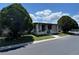 Charming home featuring a covered front porch, complemented by lush landscaping and mature trees at 34300 Countryside Dr, Wesley Chapel, FL 33543