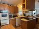 Charming kitchen offering an island cooktop, white appliances, and wood cabinets at 34300 Countryside Dr, Wesley Chapel, FL 33543