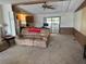 Comfortable living room featuring neutral carpeting, wood accents and a sliding glass door at 34300 Countryside Dr, Wesley Chapel, FL 33543