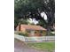 Traditional home with a well-kept lawn, mature tree, and white picket fence at 345 21St S Ave, St Petersburg, FL 33705