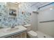 Cozy bathroom with floral wallpaper, sink, toilet, and shower with grab bar at 3542 Castle Dr, Zephyrhills, FL 33540