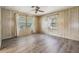 Bright bedroom with wood-look flooring and two windows at 3542 Castle Dr, Zephyrhills, FL 33540