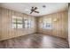 Bedroom featuring wood-look flooring, ceiling fan and large windows at 3542 Castle Dr, Zephyrhills, FL 33540