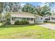 Exterior features a tan mobile home with awnings and a carport at 3542 Castle Dr, Zephyrhills, FL 33540
