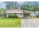 Charming tan home with awnings and carport on a well-maintained lawn at 3542 Castle Dr, Zephyrhills, FL 33540