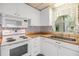 Well-equipped kitchen boasting white cabinets, wood countertops, and modern appliances at 3542 Castle Dr, Zephyrhills, FL 33540
