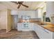 Well-lit kitchen showcasing white appliances, ample counter space, and wood-look flooring at 3542 Castle Dr, Zephyrhills, FL 33540