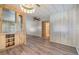 Open living space showcasing wood-style flooring and built-in shelving with glass doors at 3542 Castle Dr, Zephyrhills, FL 33540