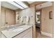 Bathroom with granite counters on vanity, large mirror and doorway leading to the bedroom at 36750 Us 19 N # 08204, Palm Harbor, FL 34684