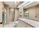 Bathroom featuring a tiled shower, vanity with granite counter, and decorative wallpaper at 36750 Us 19 N # 08204, Palm Harbor, FL 34684