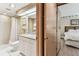Bathroom with tiled shower, single sink vanity with granite counters, and an adjacent doorway to the bedroom at 36750 Us 19 N # 08204, Palm Harbor, FL 34684