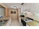 Efficient kitchen featuring white cabinets, granite countertops, and a modern electric range at 36750 Us 19 N # 08204, Palm Harbor, FL 34684