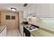 Efficient kitchen featuring white cabinets, granite countertops, and a modern electric range at 36750 Us 19 N # 08204, Palm Harbor, FL 34684