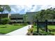 Well maintained condo building with lush lawn, mature landscaping, and decorative sign at 36750 Us 19 N # 15309, Palm Harbor, FL 34684