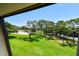 Scenic view of the golf course, mature trees, and manicured lawn from the property at 36750 Us 19 N # 15309, Palm Harbor, FL 34684