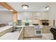 Traditional kitchen features tile backsplash, white cabinets, and stainless steel sink at 36750 Us 19 N # 15309, Palm Harbor, FL 34684