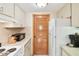 Kitchen features white appliances, tiled floor, and a pantry with wooden door at 36750 Us 19 N # 15309, Palm Harbor, FL 34684