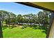 View of the manicured lawn, mature trees, and parking lot from the property at 36750 Us 19 N # 15309, Palm Harbor, FL 34684