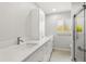 Bright bathroom features double sinks, white cabinets, and a walk-in shower at 3932 Shore Acres Ne Blvd, St Petersburg, FL 33703
