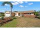 Inviting single-story home featuring a manicured lawn, mature palm tree, and a mix of brick and tan siding at 3932 Shore Acres Ne Blvd, St Petersburg, FL 33703