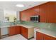 Modern kitchen with wood cabinetry, designer tile backsplash, stainless steel appliances, and abundant natural light at 3932 Shore Acres Ne Blvd, St Petersburg, FL 33703