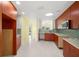 Updated kitchen with wood cabinets, stainless steel appliances, and terrazzo flooring at 3932 Shore Acres Ne Blvd, St Petersburg, FL 33703