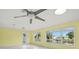 Sunlit living space with terrazzo flooring, a ceiling fan, and large windows with views of the canal at 3932 Shore Acres Ne Blvd, St Petersburg, FL 33703