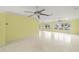 Open-concept living area featuring terrazzo floors, ceiling fans, and large windows overlooking the canal at 3932 Shore Acres Ne Blvd, St Petersburg, FL 33703