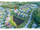 Aerial view of a home surrounded by lush greenery and a community pond at 3952 Aldea Way, Wesley Chapel, FL 33543