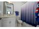 Bright bathroom with a single sink vanity, modern fixtures, and a blue patterned shower curtain at 3952 Aldea Way, Wesley Chapel, FL 33543