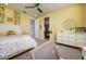 Yellow bedroom featuring carpet flooring, ceiling fan, and closet for storage at 3952 Aldea Way, Wesley Chapel, FL 33543